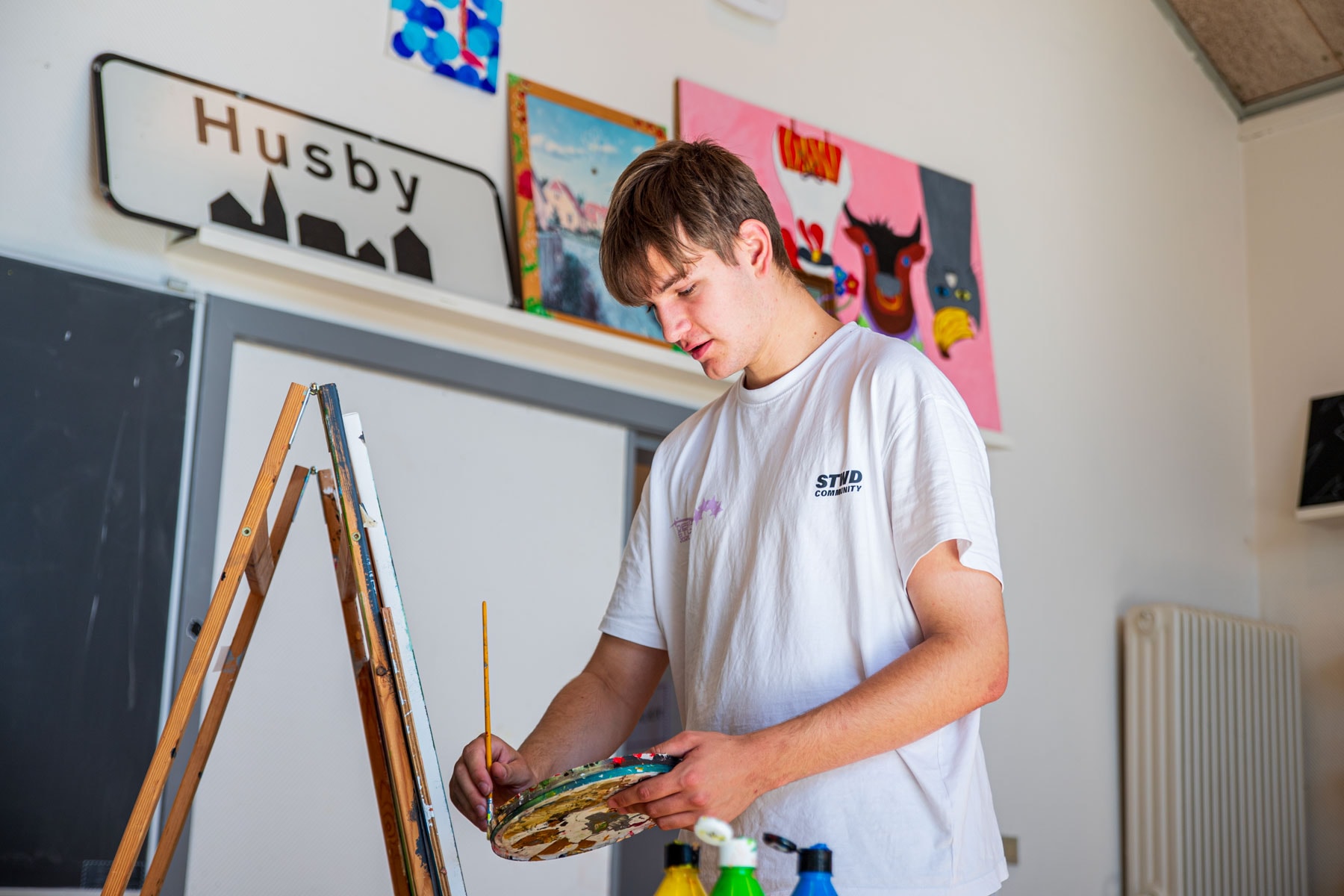 Elev maler på lærred i kunstlokalet på profilfaget ArtXpress på Husby Efterskole