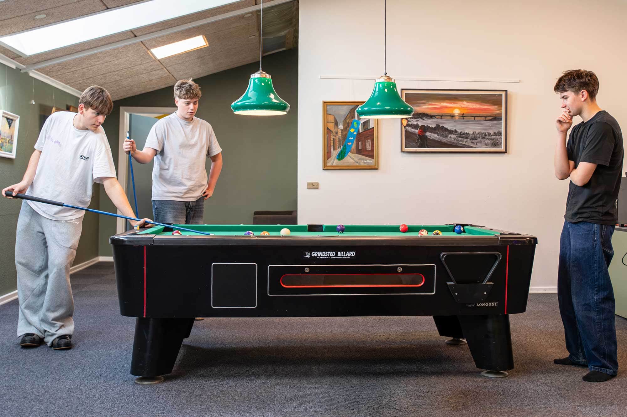 Tre elever spiller billard sammen i fritiden på Husby Efterskole