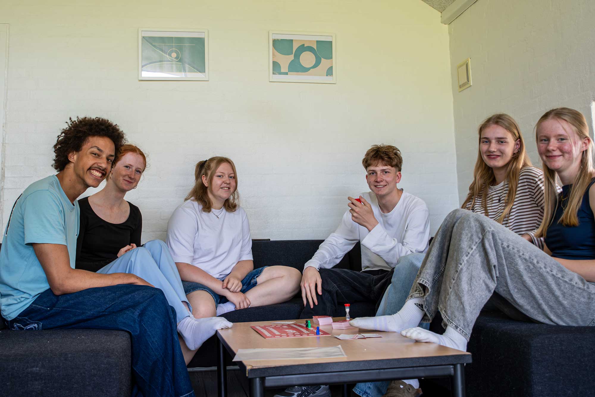 Elever hygger sammen med brætspil i et fællesområde på Husby Efterskole