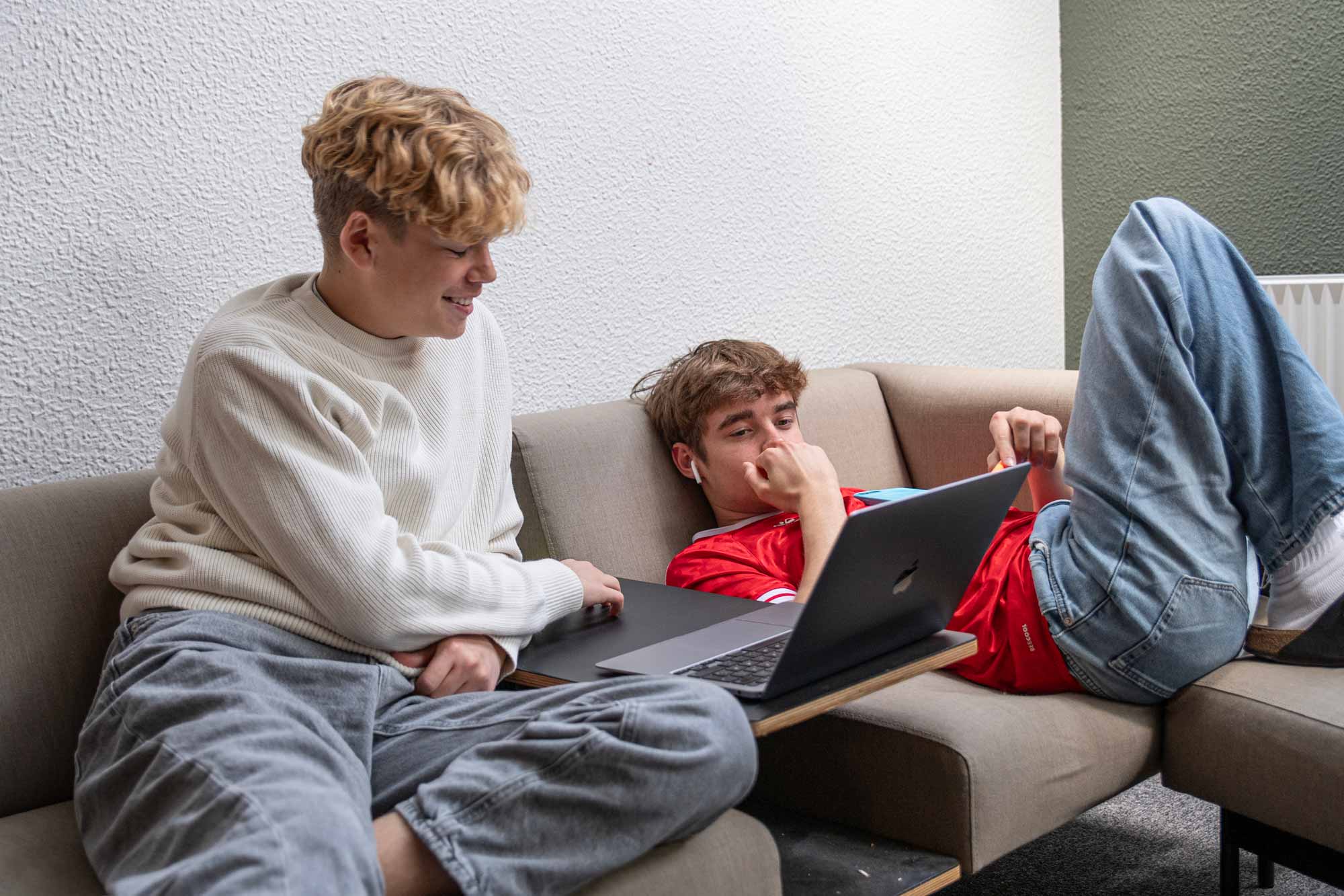To elever arbejder sammen med en computer i et fællesområde på Husby Efterskole