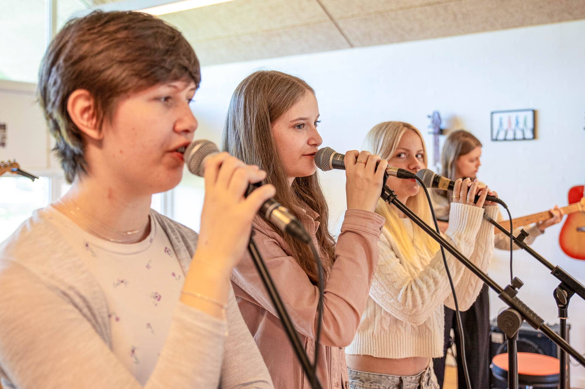 Elever synger sammen i mikrofoner på profilfaget Band på Husby Efterskole
