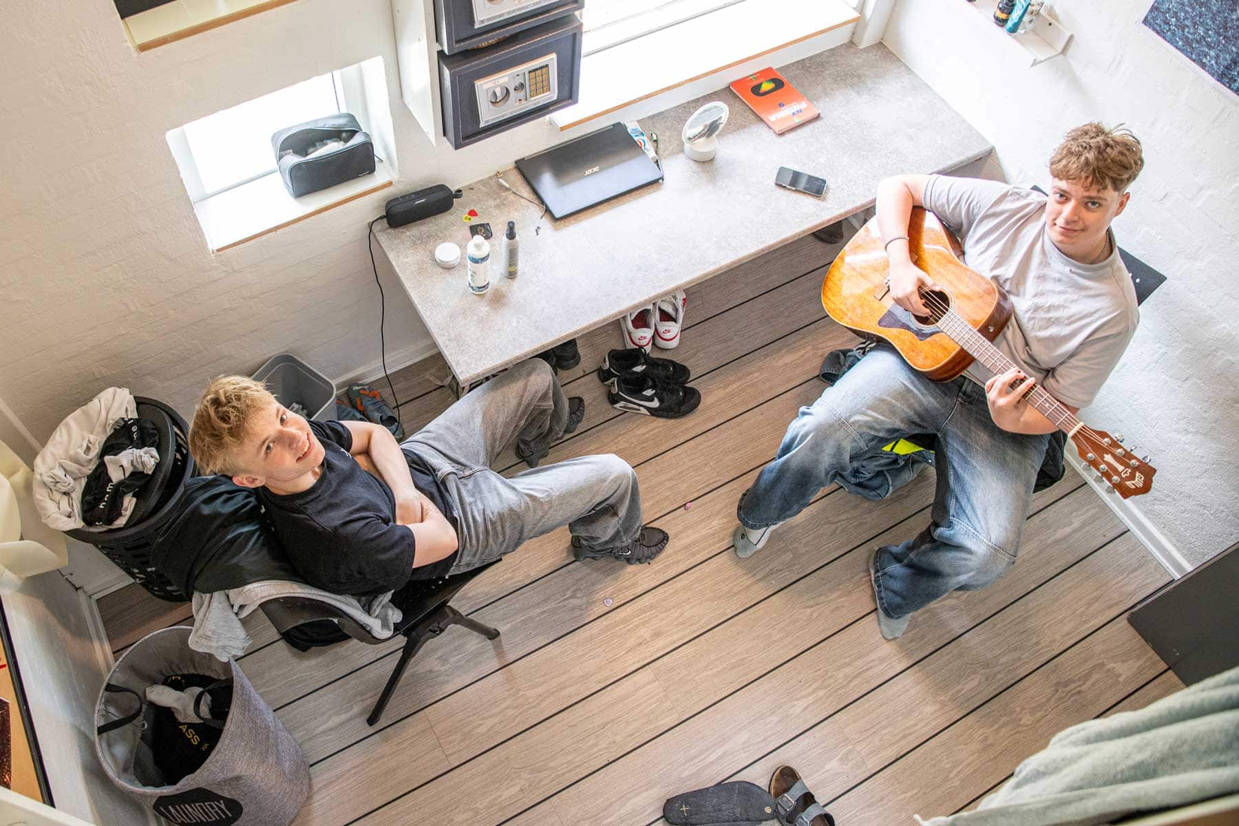 To elever hygger på et elevværelse på Husby Efterskole, mens den ene spiller guitar