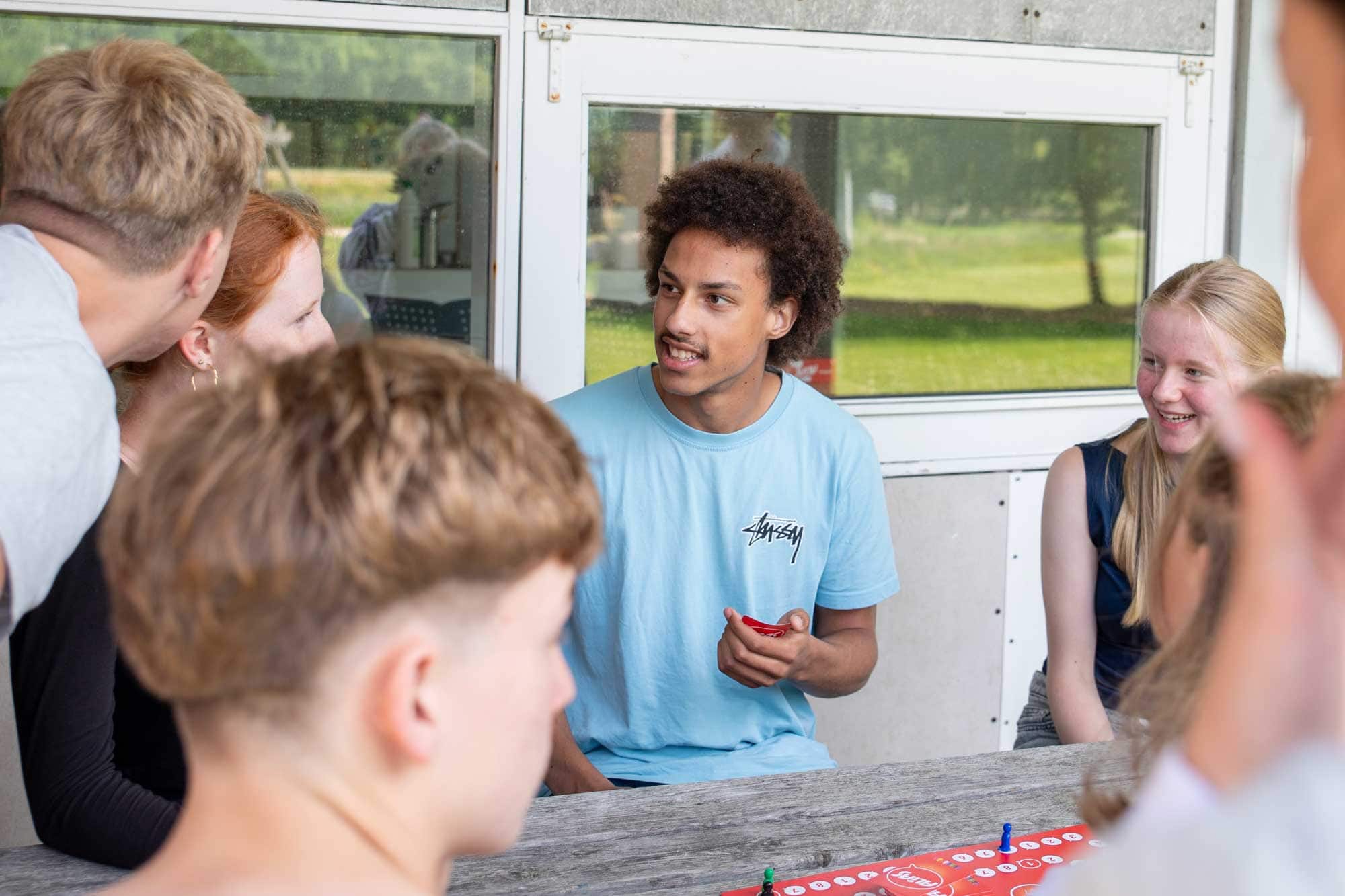 Elever hygger sig sammen omkring et bord på Husby Efterskole