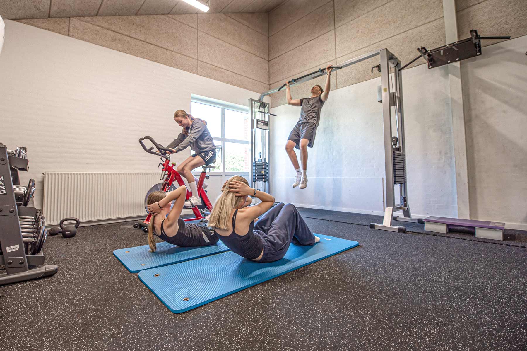 Elever træner sammen i fitnessrummet på Husby Efterskole