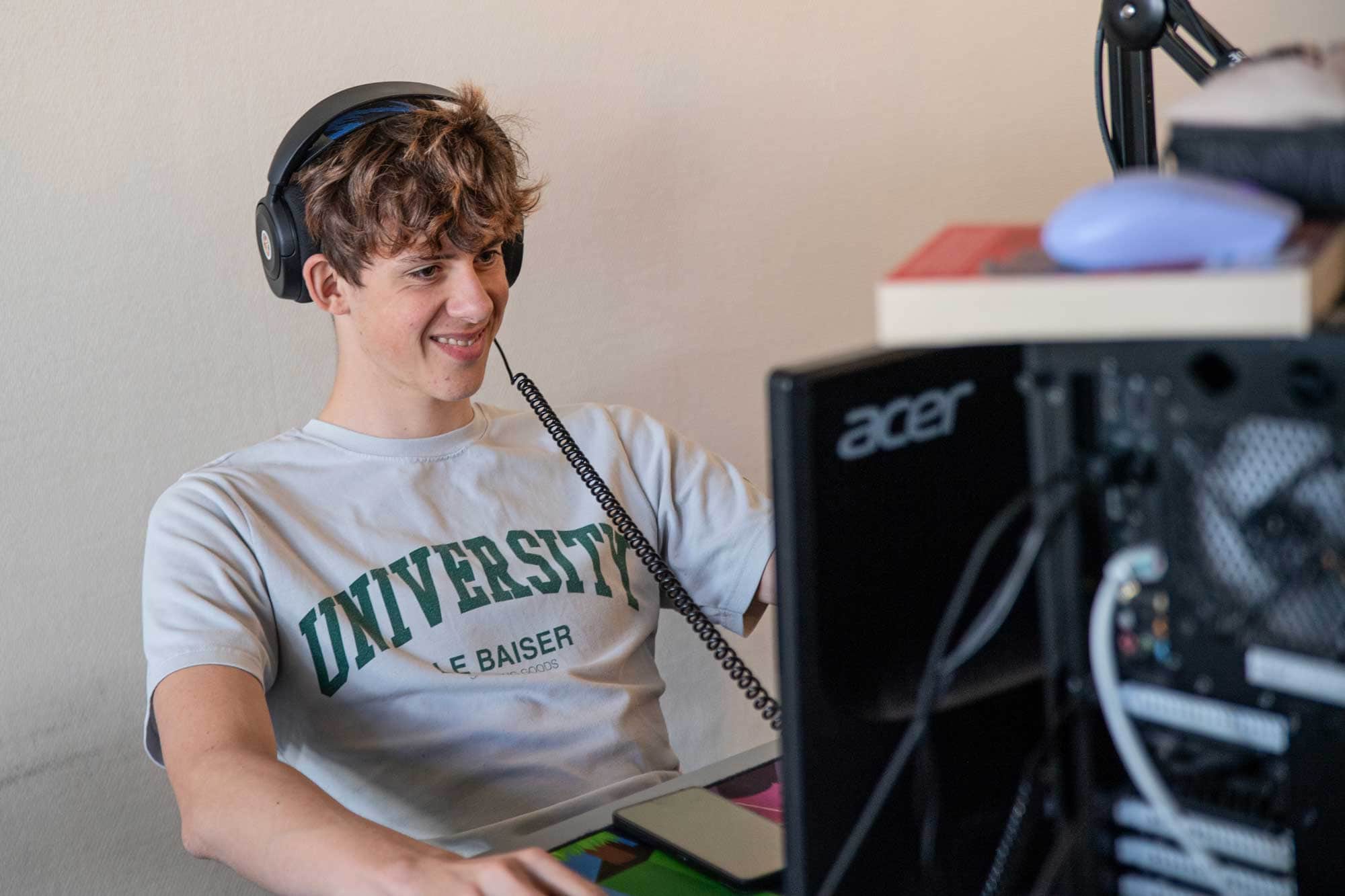 Elev gamer ved computer i fritiden på Husby Efterskole
